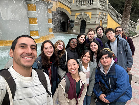 The Trek group and PUC students pose in front of a fountain